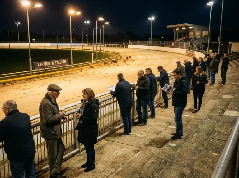 Evening atmosphere at Yarmouth greyhound stadium with floodlights and spectators